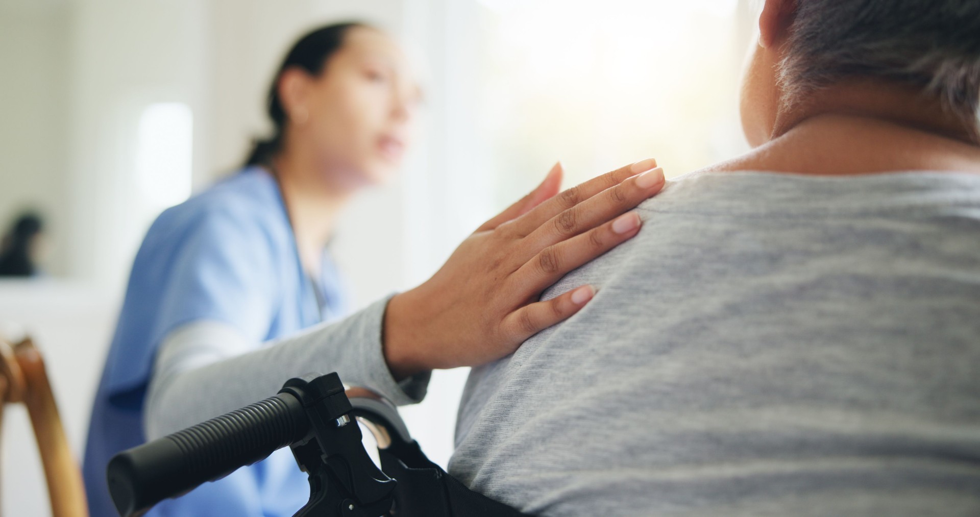 Woman, hand and nurse with patient in wheelchair for elderly care, support or trust at old age home. Closeup of medical doctor or caregiver listening to person with a disability for health advice